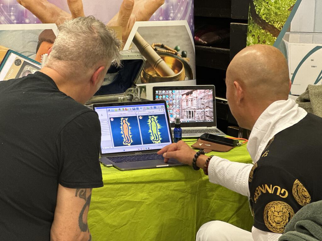 Jibin Chi visar Holistic Bioenergy Analysis för en besökare på Harmoni Expo