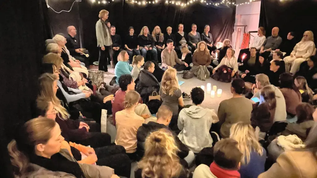 Fullsatt prova-på-pass på Hyllan med deltagare i en ring kring levande ljus