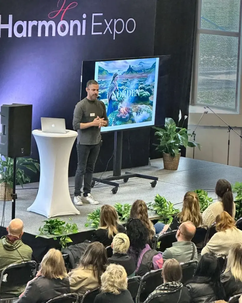 En föreläsare på Scenen med fullsatta stolsrader framför